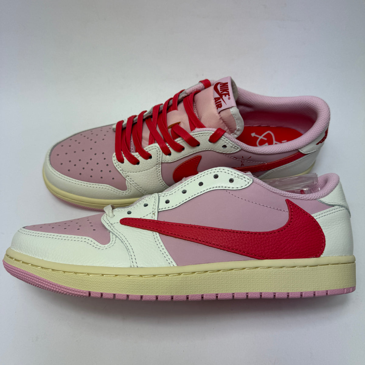 Seitenansicht des Travis Scott x Air Jordan 1 Low Sail Tropical Pink mit hellem Colorblocking und charakteristischem Reverse Swoosh