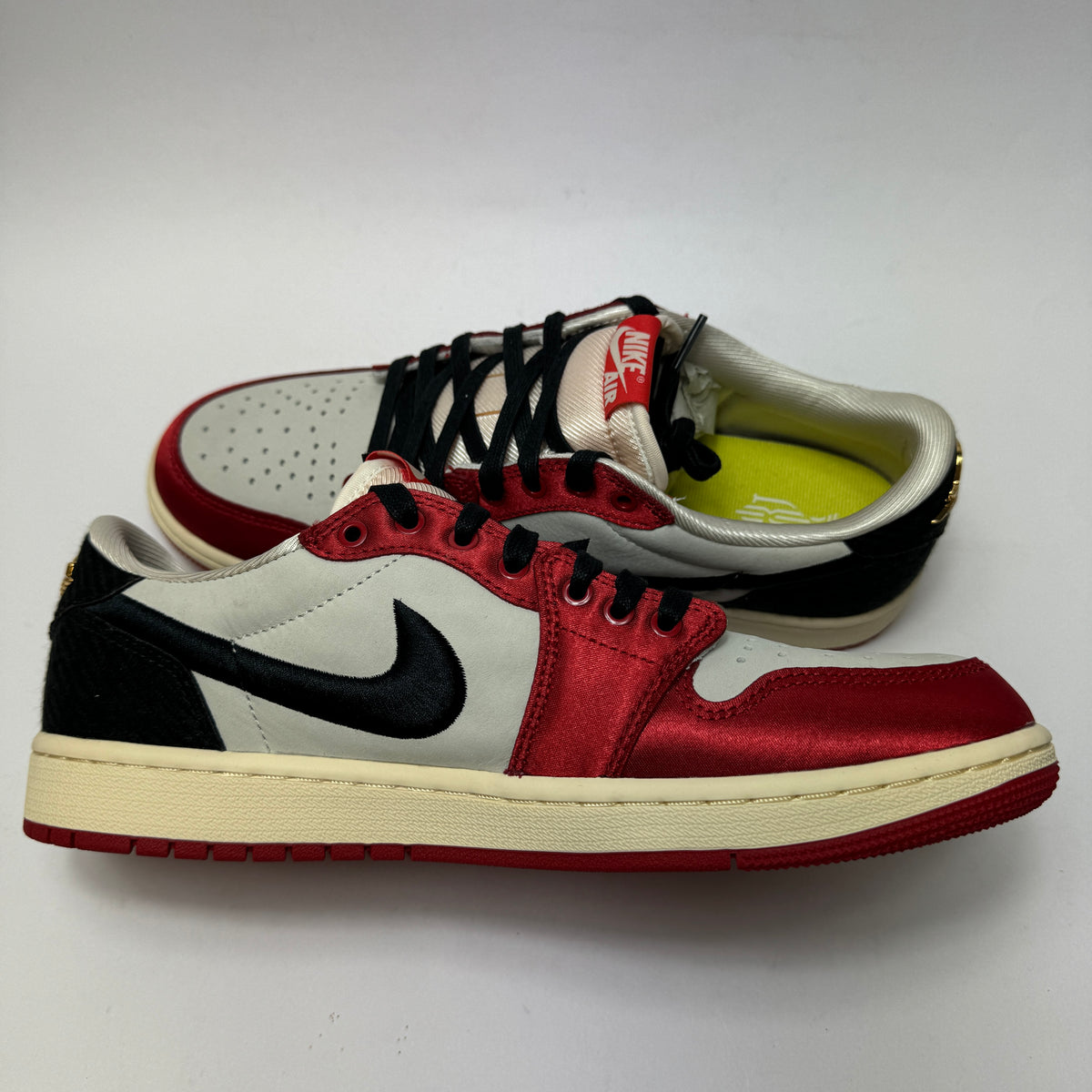 Innenansicht des Trophy Room x Air Jordan 1 Low OG Away mit Sail-, Schwarz- und Varsity-Red-Colorblocking