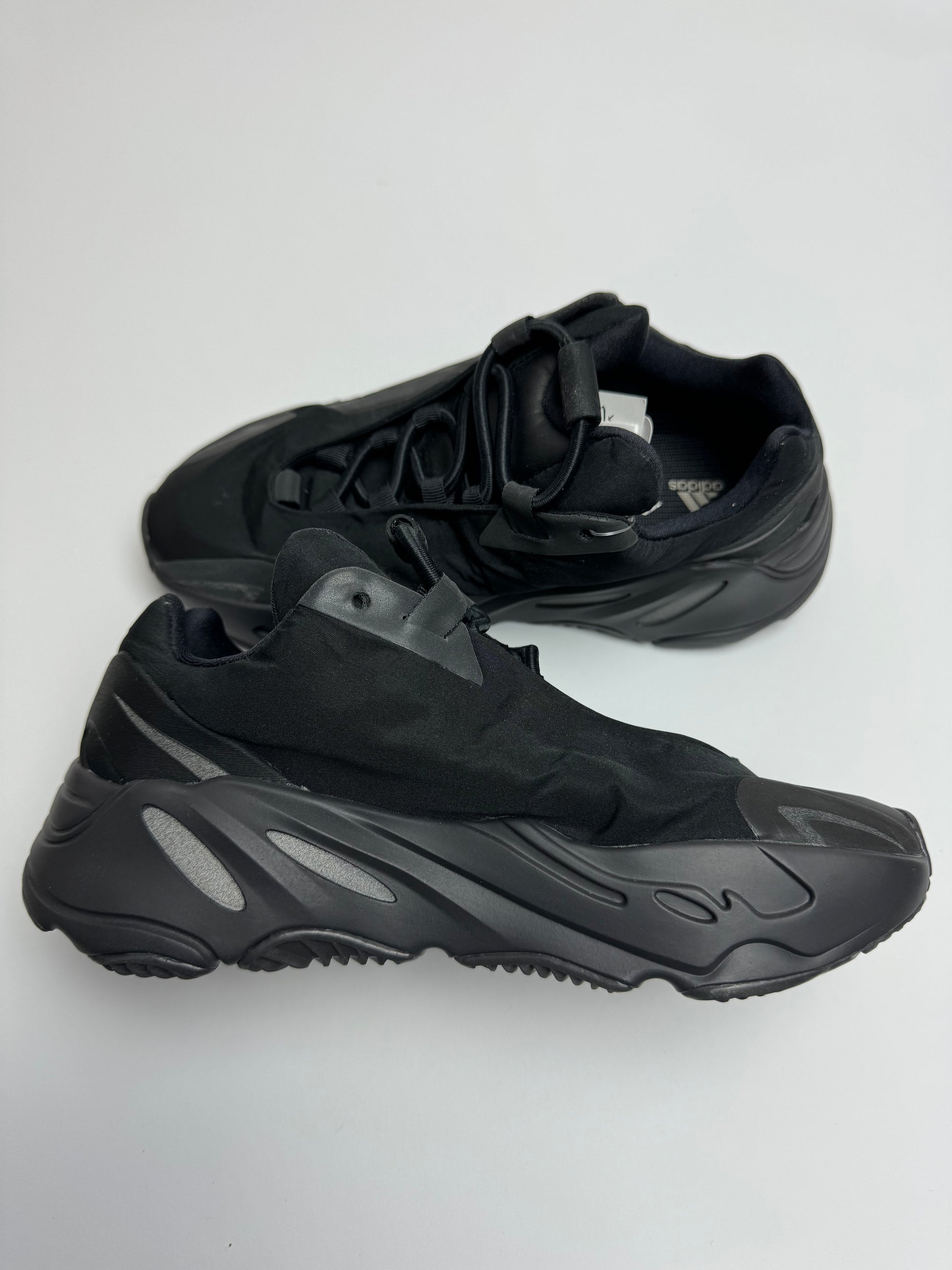 Yeezy 700 MNVN Triple Black – linke Außenseite mit reflektierendem 3M‑700‑Print und schwarzen Overlays