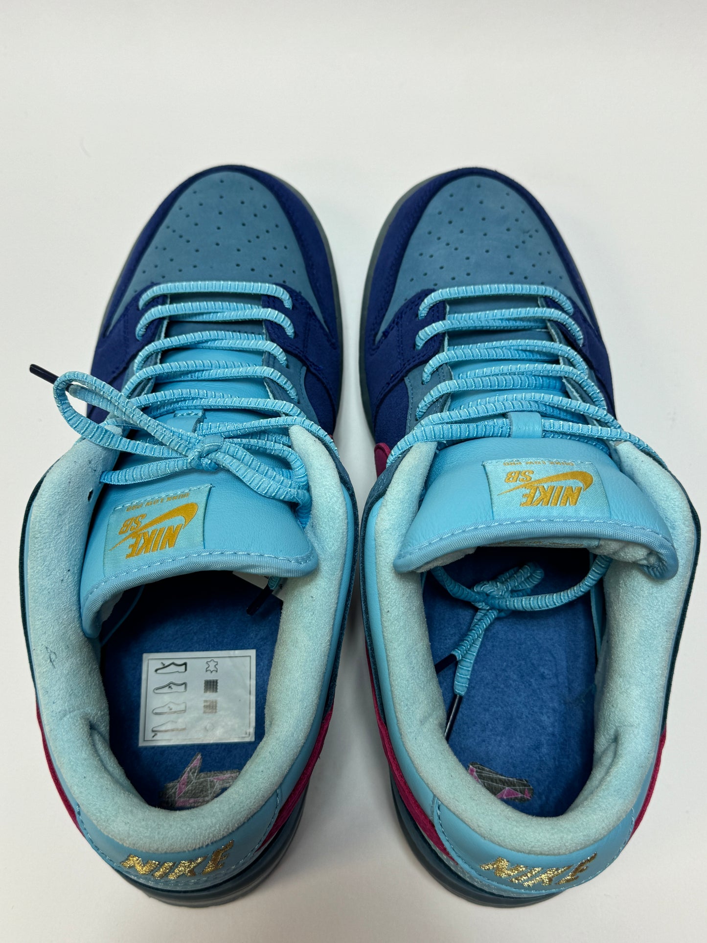 Nike SB Dunk Low Run The Jewels Frontansicht – Paaraufnahme in Blau- und Türkistönen mit Active Pink Details, sichtbarer Used-Zustand