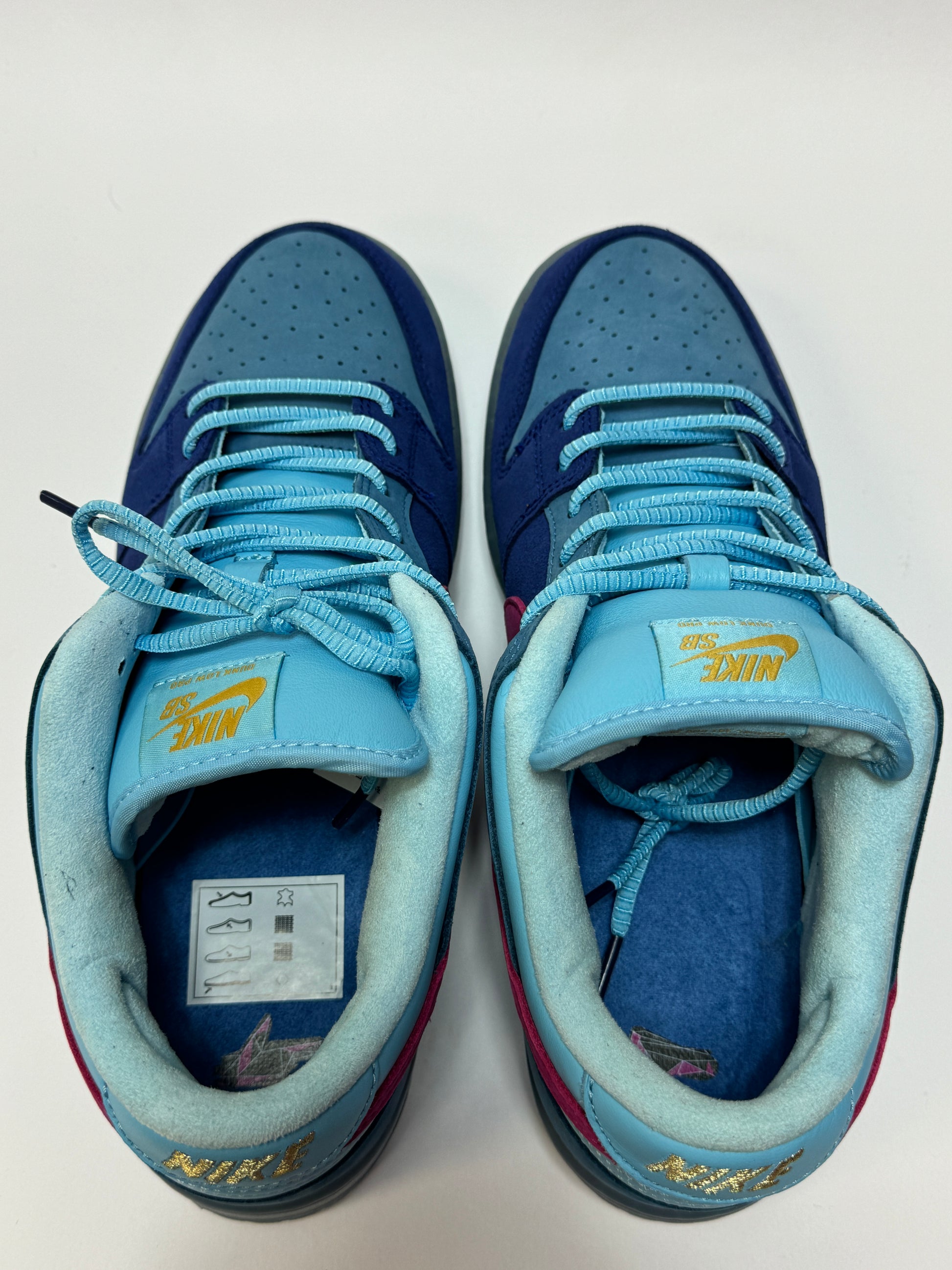Nike SB Dunk Low Run The Jewels Frontansicht – Paaraufnahme in Blau- und Türkistönen mit Active Pink Details, sichtbarer Used-Zustand