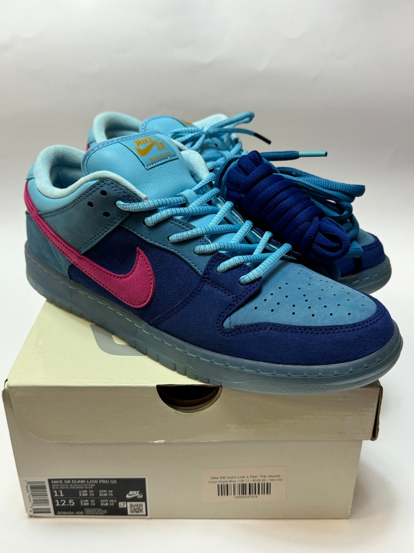Nike SB Dunk Low Run The Jewels Seitenansicht auf Box – blaues Suede Upper, pinker Swoosh, zusätzlicher Lace-Stack, Used-Zustand dokumentiert
