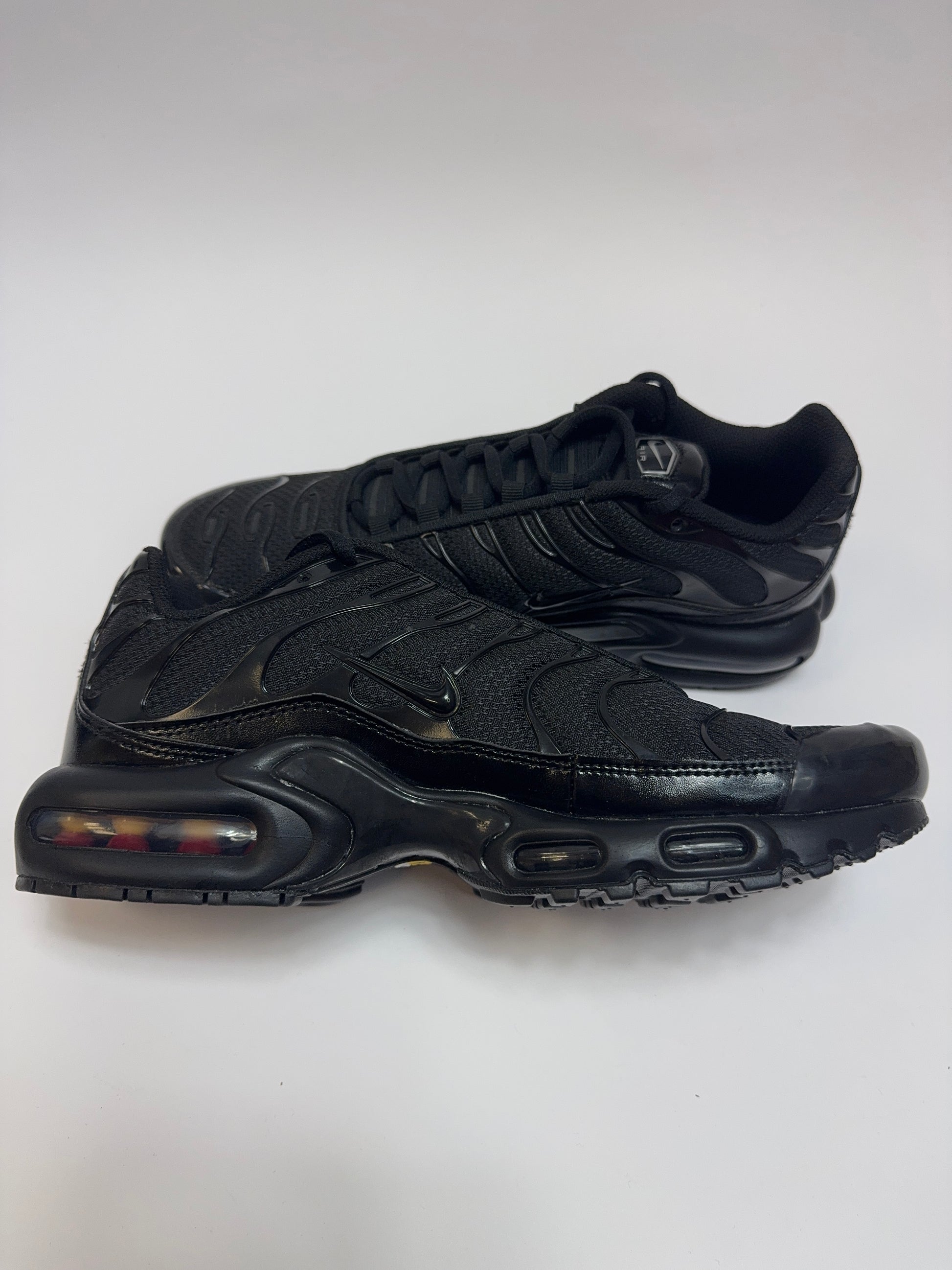 Nike Air Max Plus Triple Black linke Ansicht mit markanter TPU-Rippung und schwarzem Design